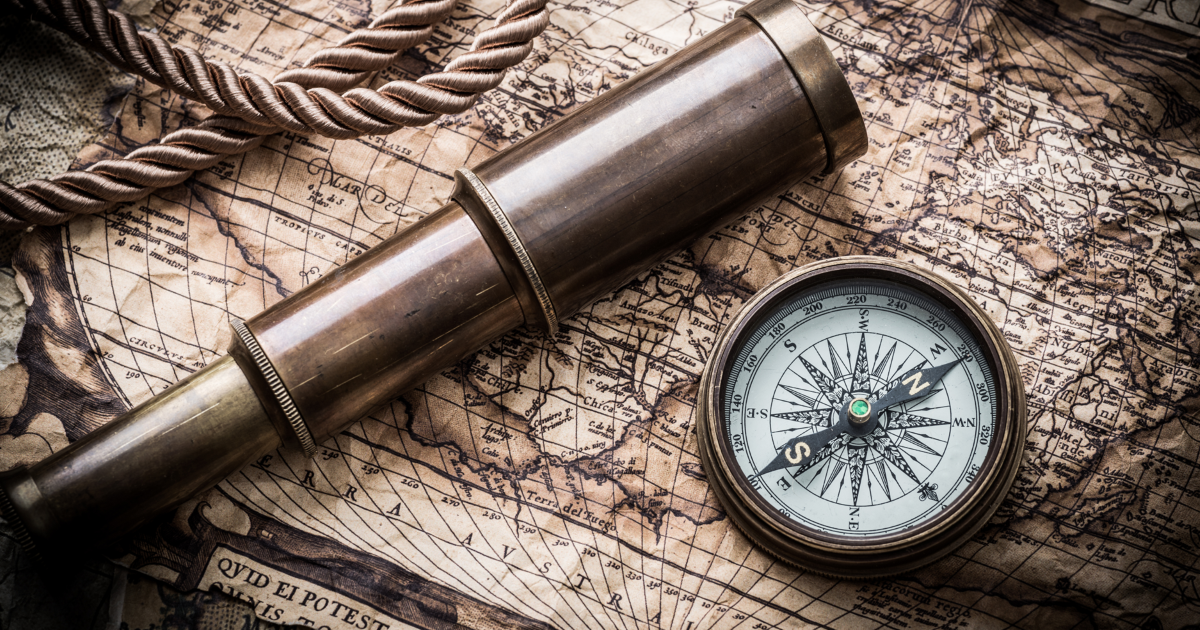 Compass and spyglass on map
